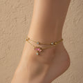 18K gold plated double-layer anklet featuring a pink enamel lotus flower charm and clear crystal accents on a white background.