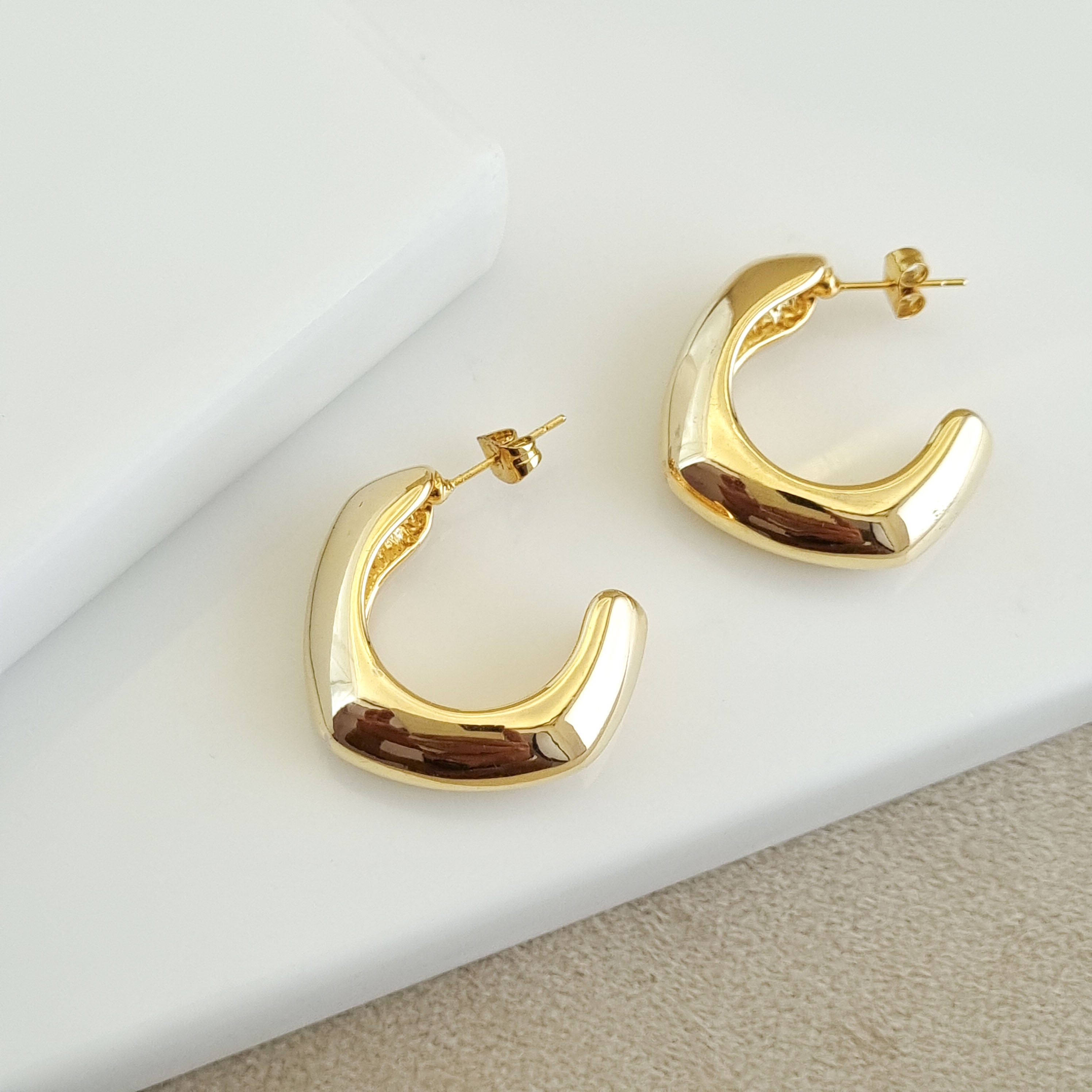 18K gold-plated volumetric hoops, waterproof gold earrings, anti-tarnish statement huggies, hypoallergenic luxury jewelry, sculptural gold earrings, thick "C" hoop earrings.