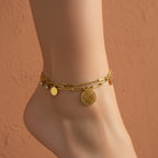 18K gold plated layered anklet featuring a Flower of Life charm, paperclip chain, and gold disc accents on a white surface.