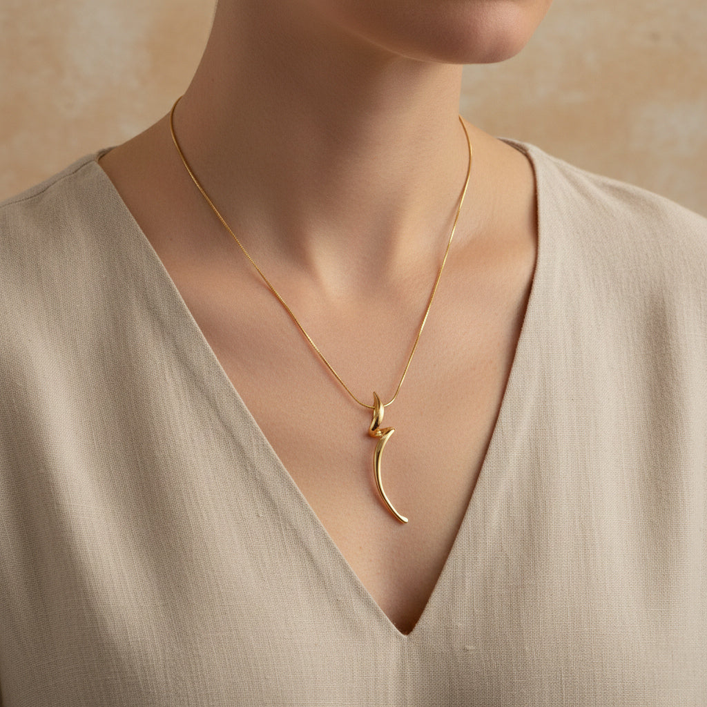 A woman wearing an 18K gold-plated necklace featuring a twisted, organic "molten" style flare pendant on a minimalist neutral background.
