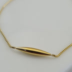 18K gold plated anti tarnish anklet with a central gold tube charm and two gold beads on a micro-box chain.