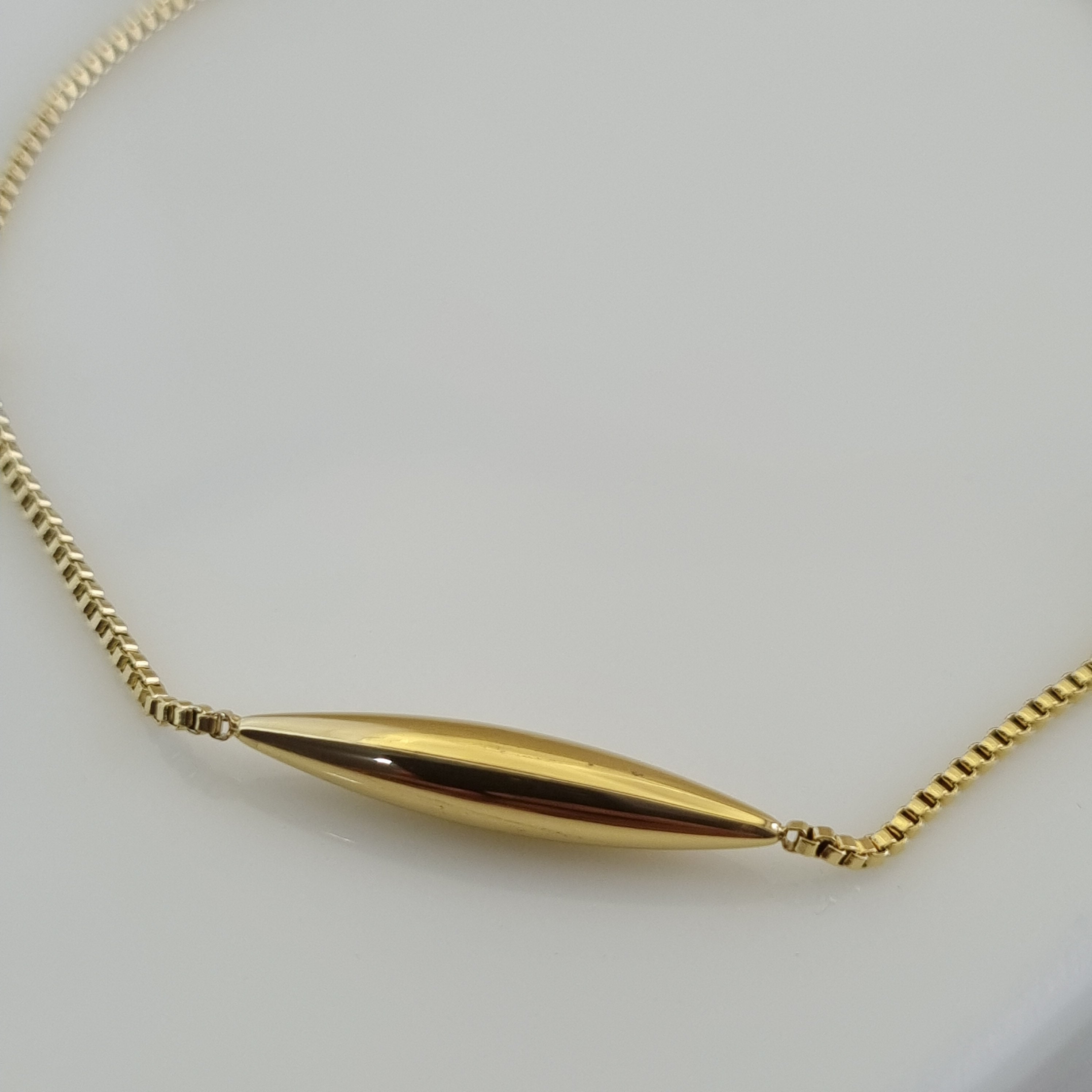 18K gold plated anti tarnish anklet with a central gold tube charm and two gold beads on a micro-box chain.