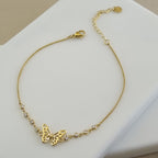 18K gold plated anklet featuring a butterfly charm and several bezel-set crystals on a delicate micro-box chain.