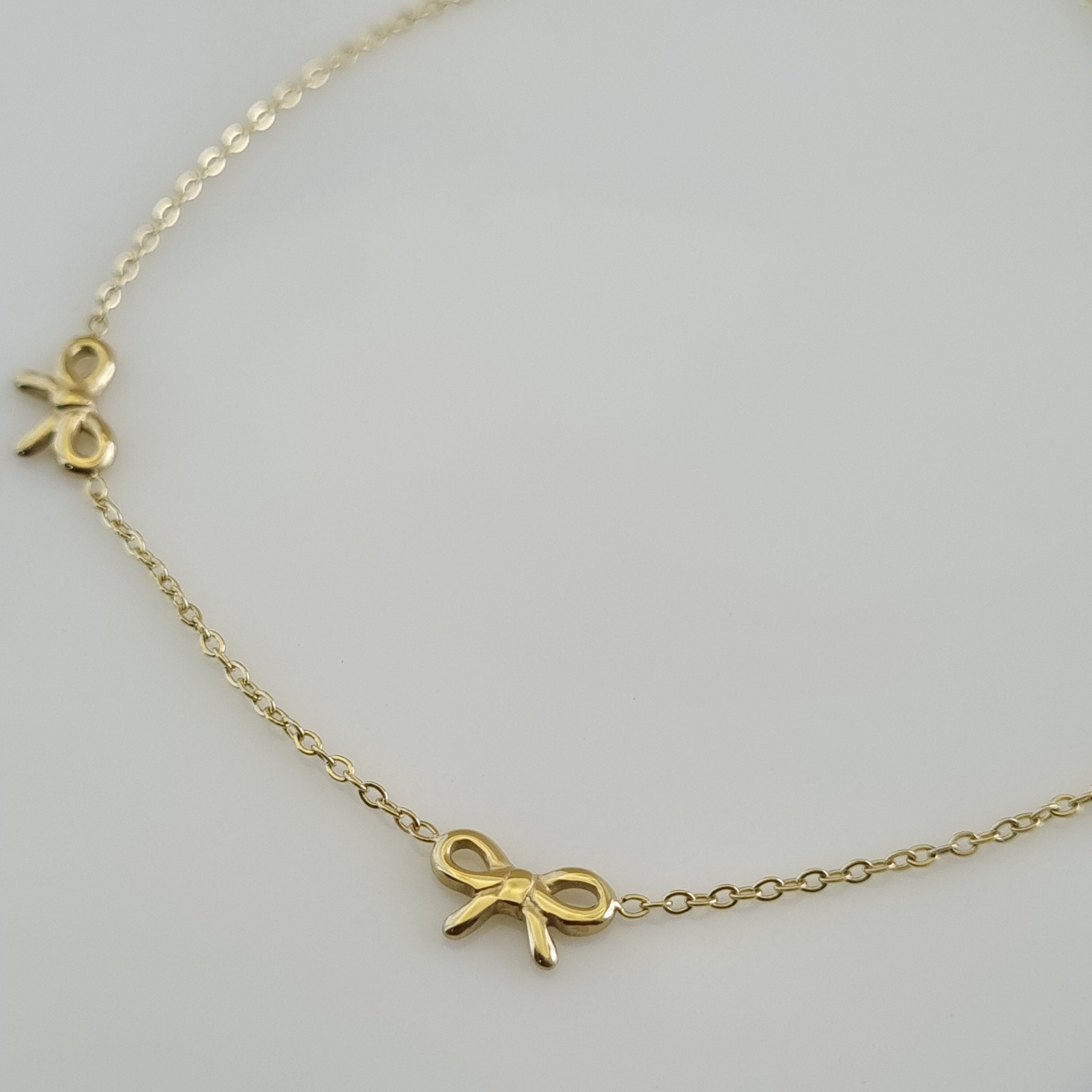 18K gold plated anklet with three small bow charms on a delicate gold cable chain.