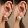 Close up of a woman's ear wearing 18K gold-plated pearl jacket earrings with a small pearl in front and a larger pearl in a molten gold setting behind the lobe.