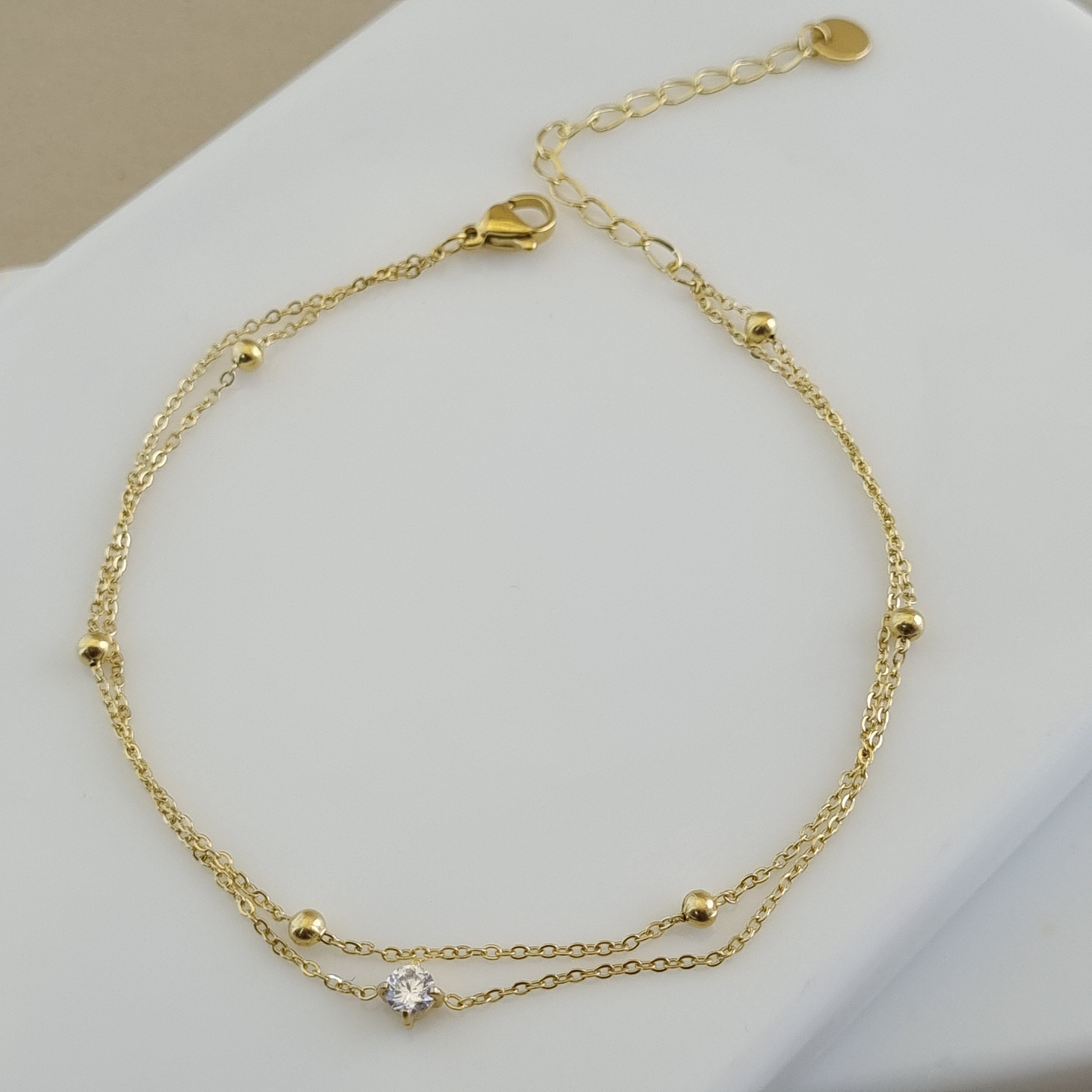Zirconia charm anklet, gold bead anklet, minimalist layered jewelry, summer jewelry trends 2026, dainty gold anklet for women.