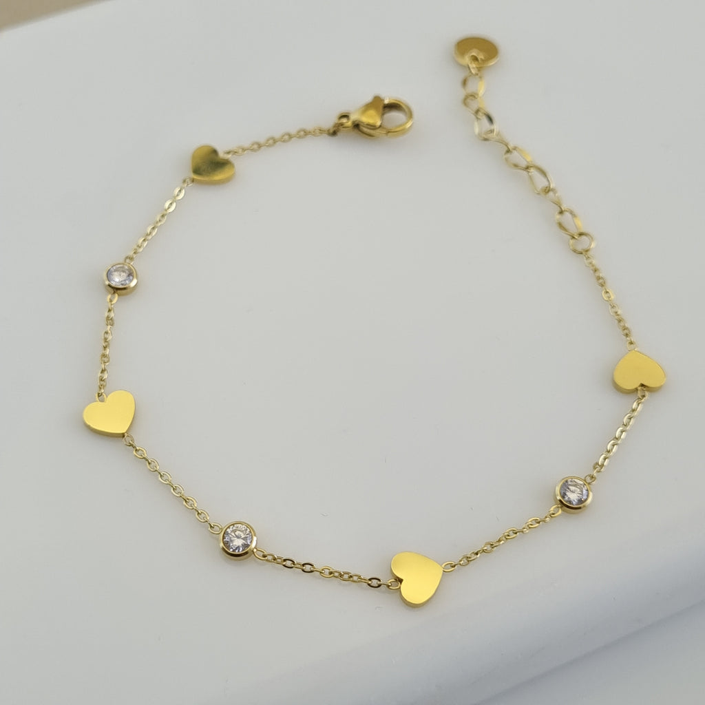Treshire 18K gold plated Whimsical Heart bracelet with alternating heart charms and bezel-set crystals on a fine gold chain.