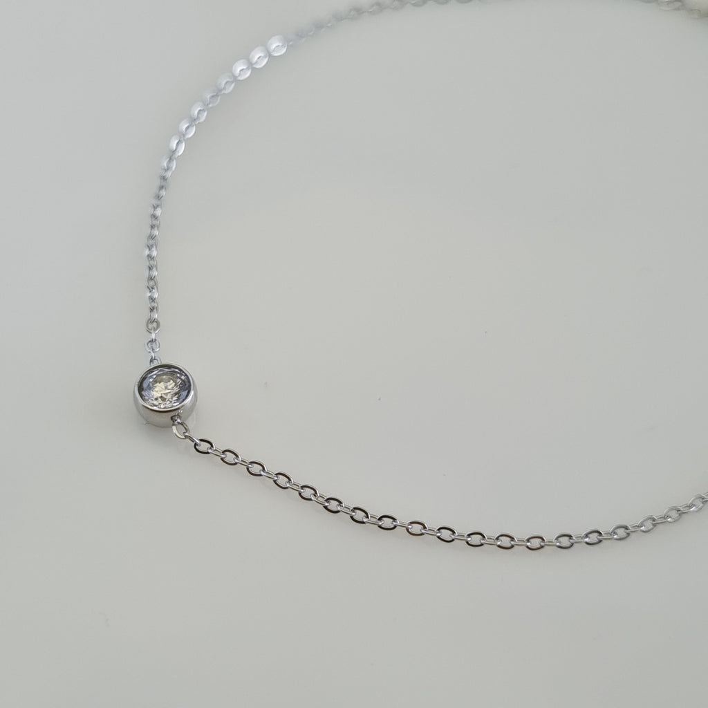Treshire silver-tone solitaire bracelet with a single bezel-set crystal on a fine chain, displayed on a white surface.