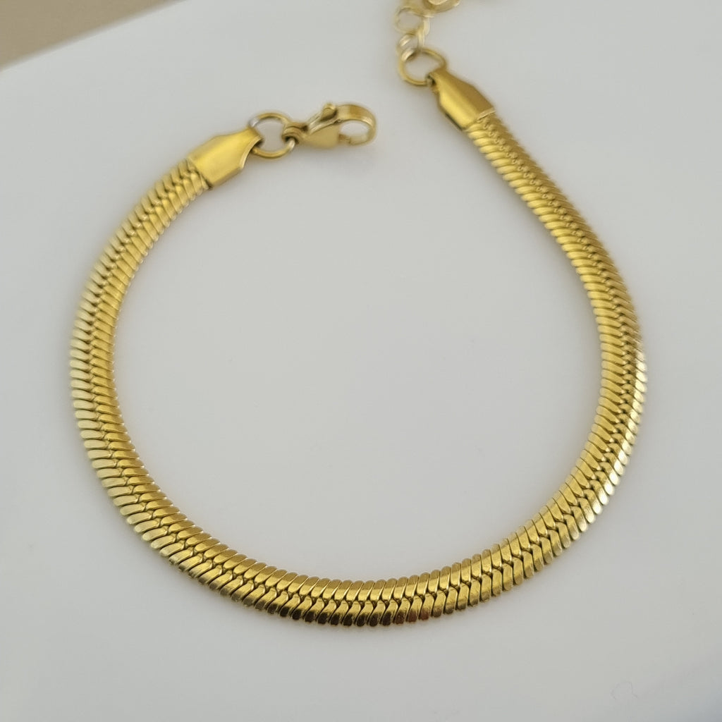 Treshire 18K gold plated Verona snake chain bracelet with a flat herringbone weave displayed on a white surface.