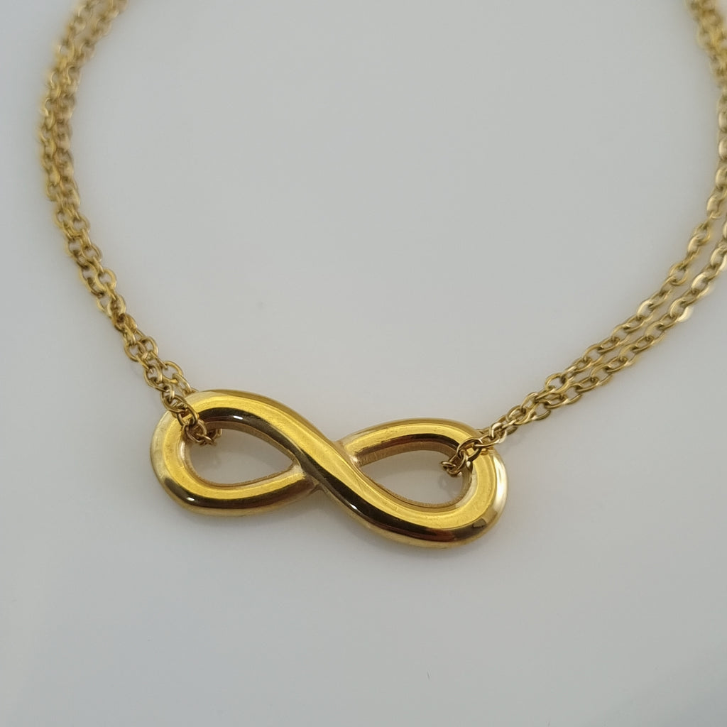 Treshire 18K gold plated Eternal Bond bracelet featuring an infinity symbol on a double-strand gold chain, displayed on a white surface.