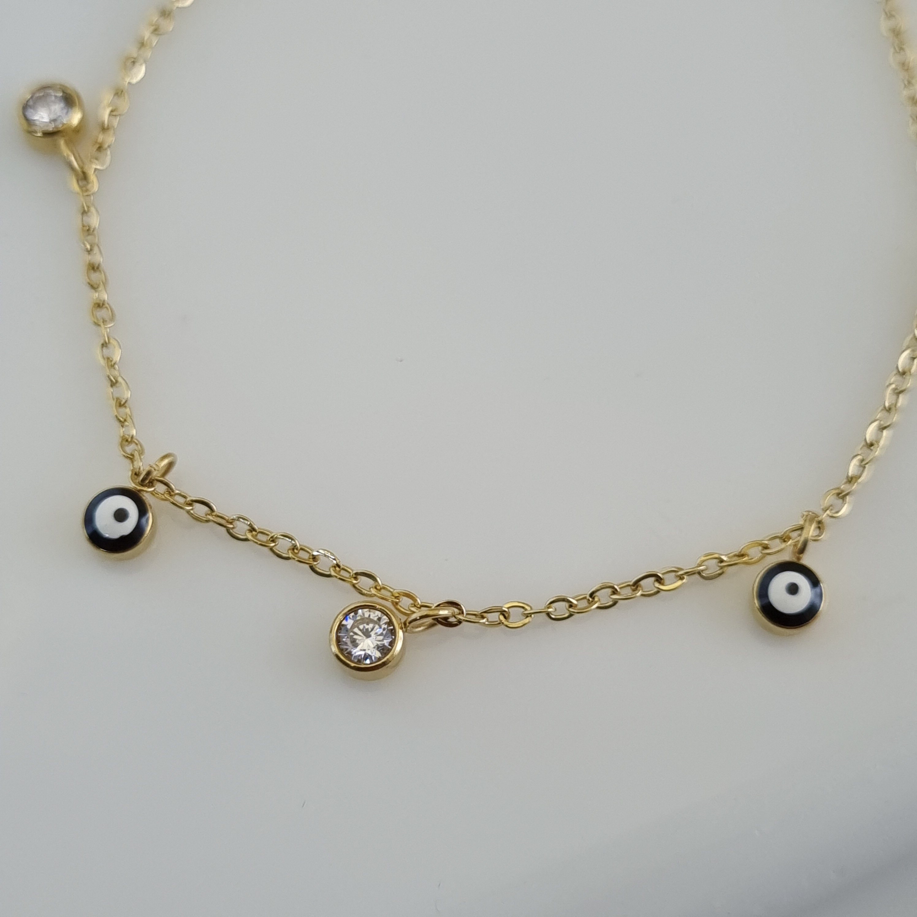 Treshire 18K gold plated Nazar bracelet with alternating blue evil eye charms and bezel-set crystals on a fine gold chain.