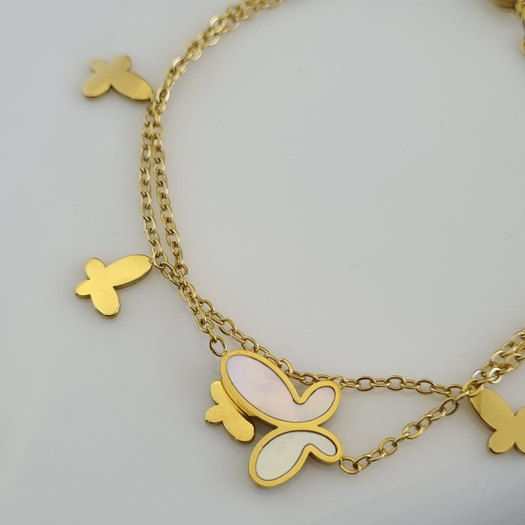 Treshire 18K gold plated double chain bracelet with a central Mother of Pearl butterfly and four gold butterfly charms displayed on a white surface.
