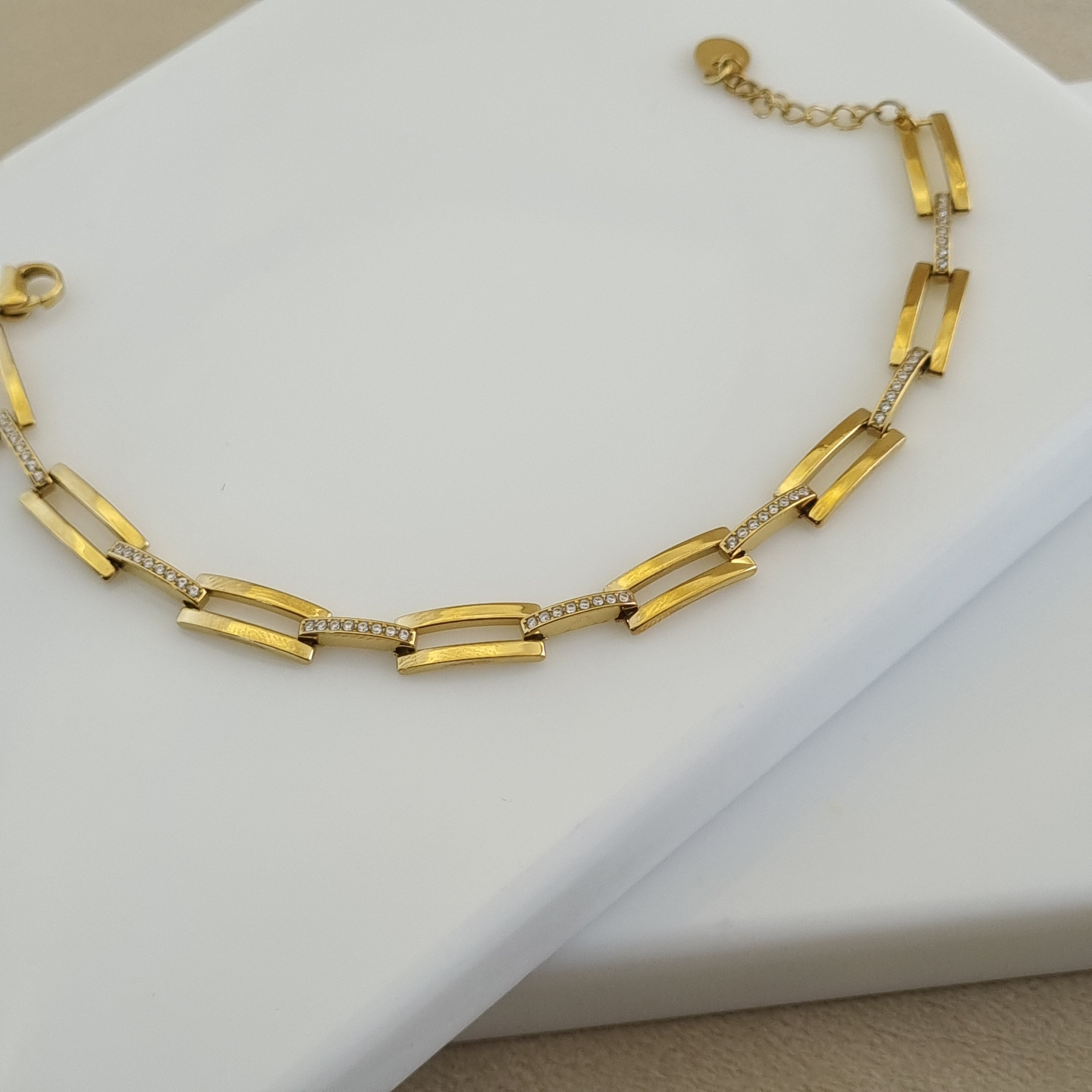18K gold plated link bracelet featuring polished rectangular links and micro-pave zirconia crystal accents.