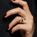 A woman with deep burgundy nails wearing an 18K gold-plated, size-adjustable spiral wrap ring featuring two brilliant-cut crystal terminals.
