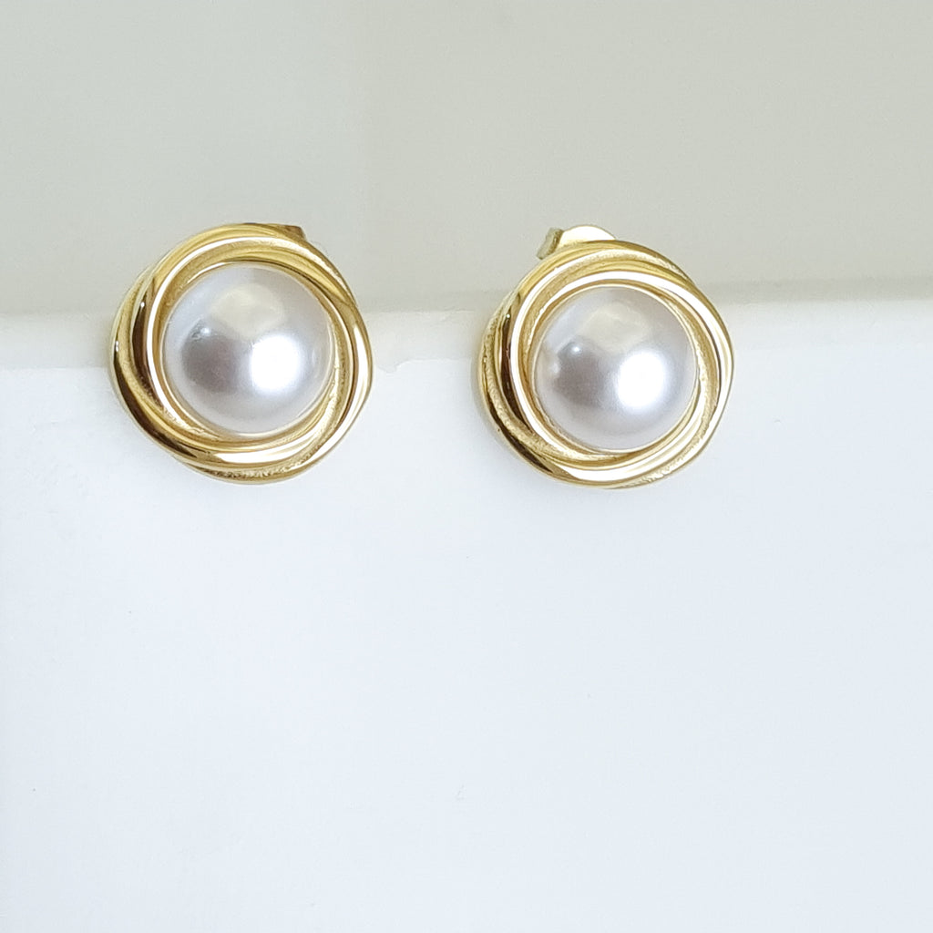 Gold earrings with pearl-like centers on a white background