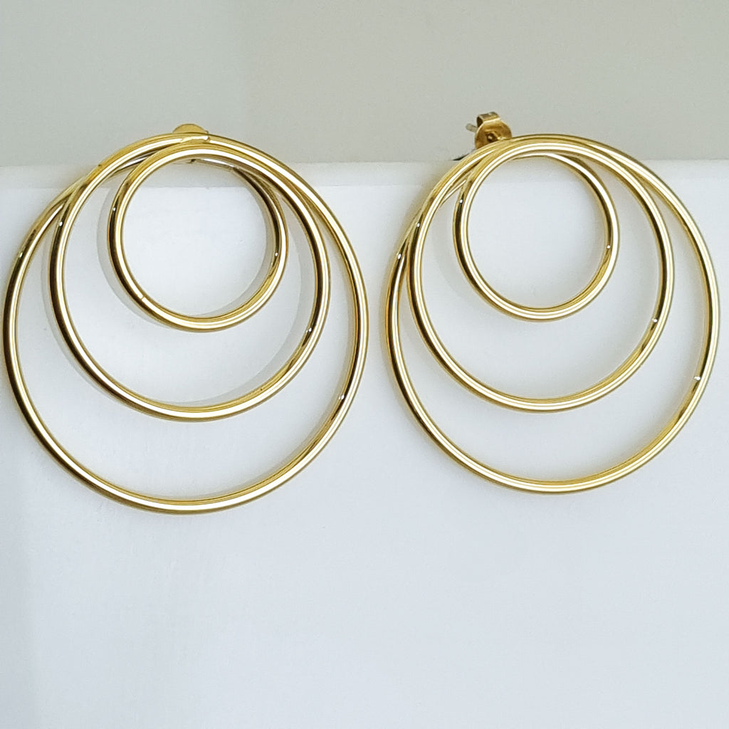 Gold hoop earrings on a light gray background